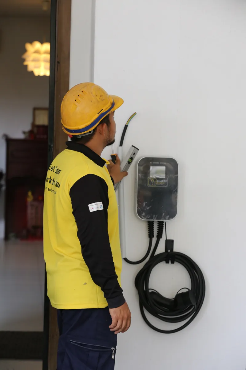 An installer in a hard hat fitting an RSX-1K charger to a wall